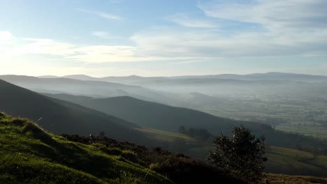 distant misty dreamlike layers of panoramic rural mountain valley peaks countryside at sunrise