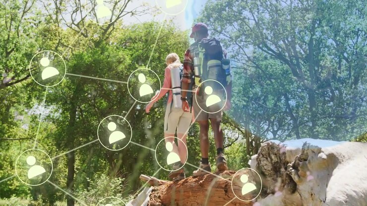Donna che precede e uomo che segue camminando su un tronco, con nodi di rete tecnologica che si attivano e riempiono la foresta.