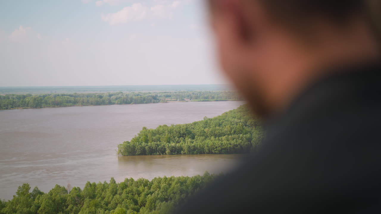 Blurry person enjoys landscape with large tranquil river