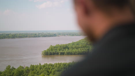 blurry person enjoys landscape with large tranquil river