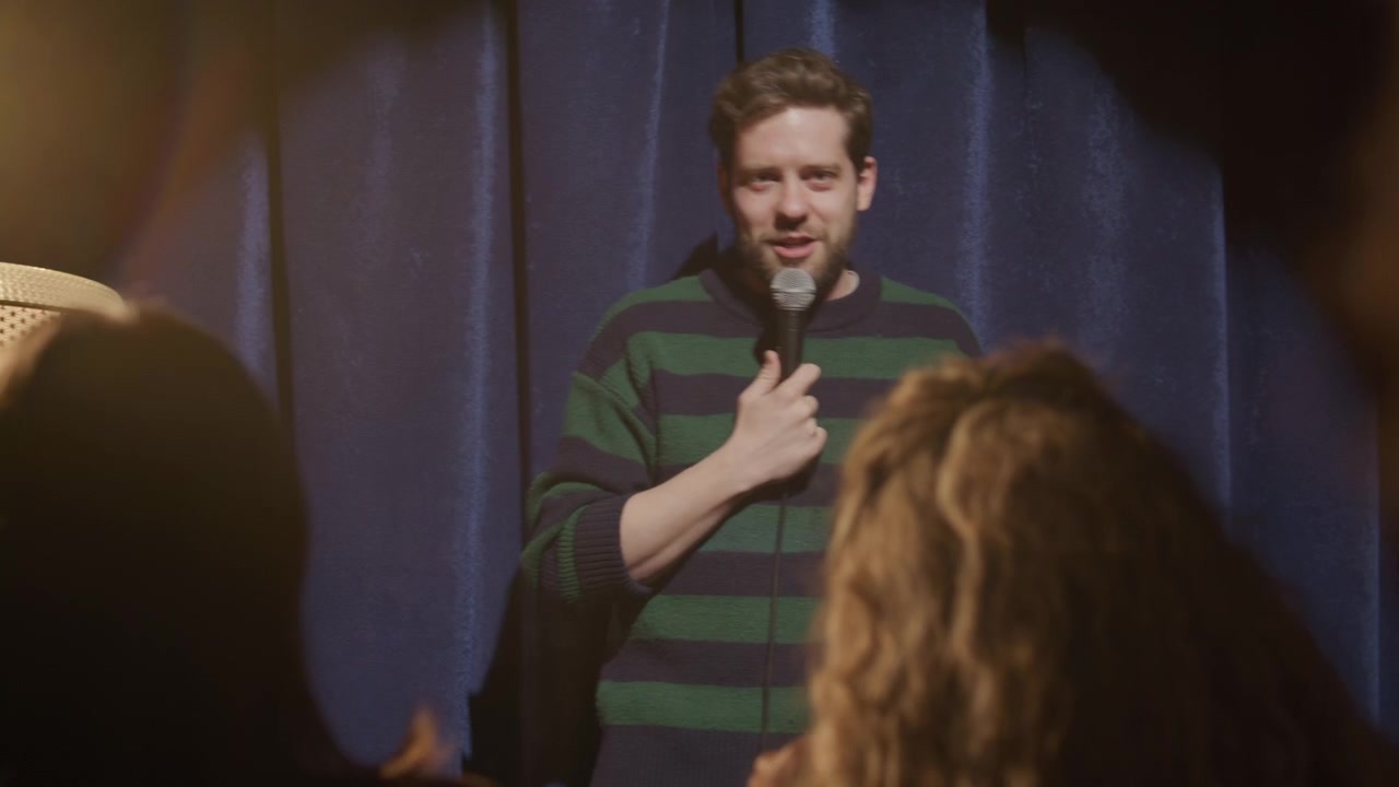 Stand-up comedian die optreedt op het podium voor een lachend publiek