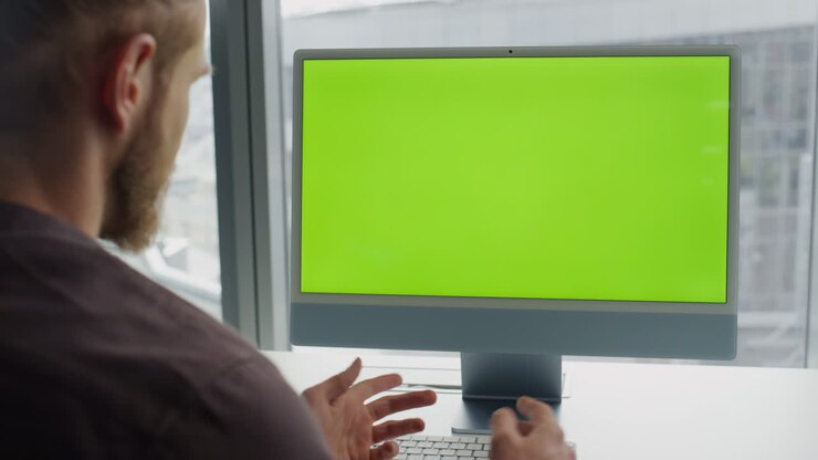 Uomo in videochiamata con computer chromakey in ufficio. Videochiamata di uno specialista sconosciuto