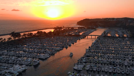 imágenes de drones de un barco de pesca llegando al puerto al atardecer