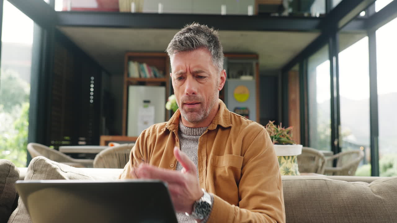 Uomo pensieroso che lavora al laptop in una casa moderna