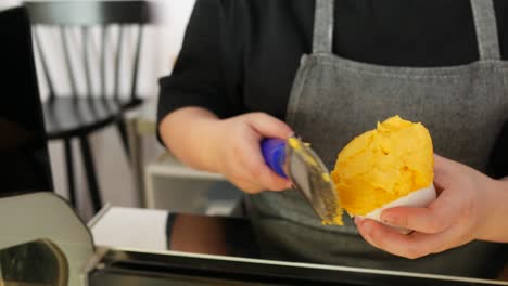 mano recogiendo helado con una cuchara de un plato