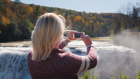 Frau-Fotografiert-Wasserfall-Im-Herbstlichen-Wald