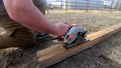 slow motion - cutting a 4x4 wooden post with a circular saw