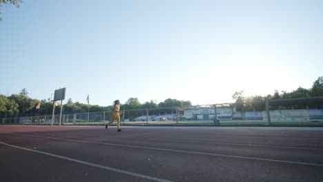 woman jogging on outdoor track in sportswear at athletic field