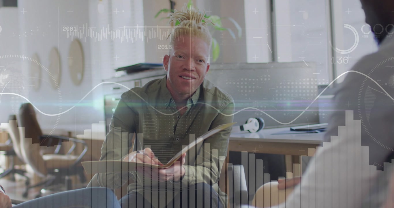 Seated man presenting business data, gesturing pen causing charts sweeping screen, flipping notes