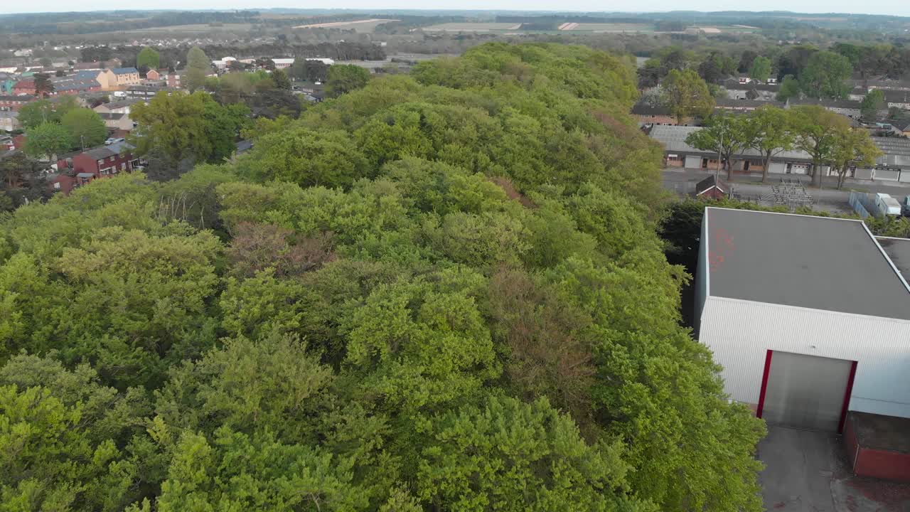 Forward moving clip over a small forest during Spring on an English village