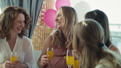 group of caucasian women drinking cocktails at baby shower.