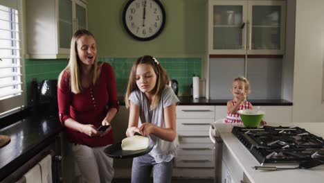 mother and daughters cooking crepes together