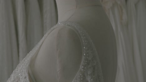 a close-up view of a wedding gown is presented in a wedding salon