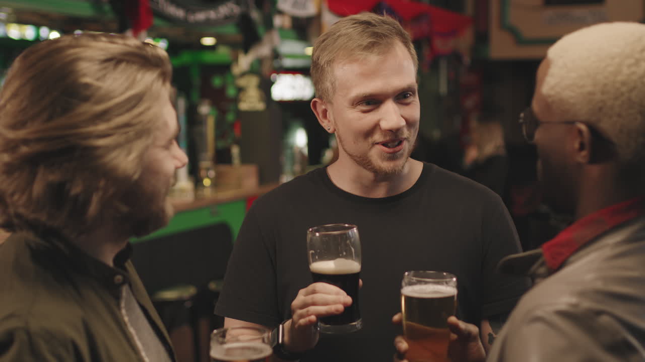 Male Friends Chatting At Bar Drinking Beer