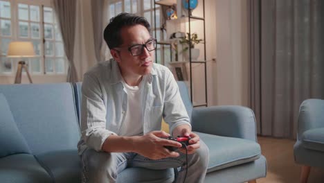 bored asian man using joystick playing a game at home