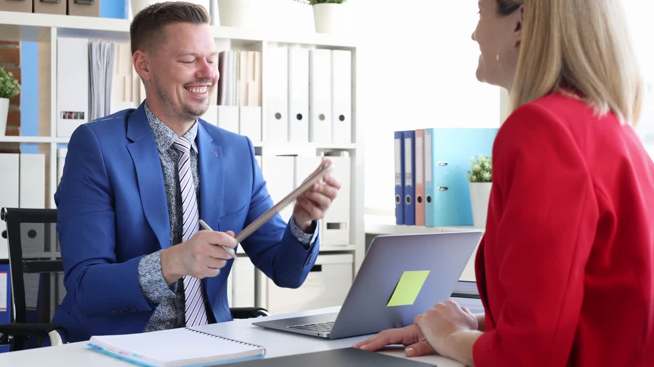 un hombre de negocios sonriente muestra un currículum en blanco a una mujer de negocios película en 4k