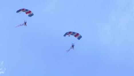 two people flying with parachutes at an air show in berlin