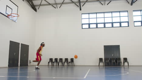 african american male basketball player playing basketball, running in gym