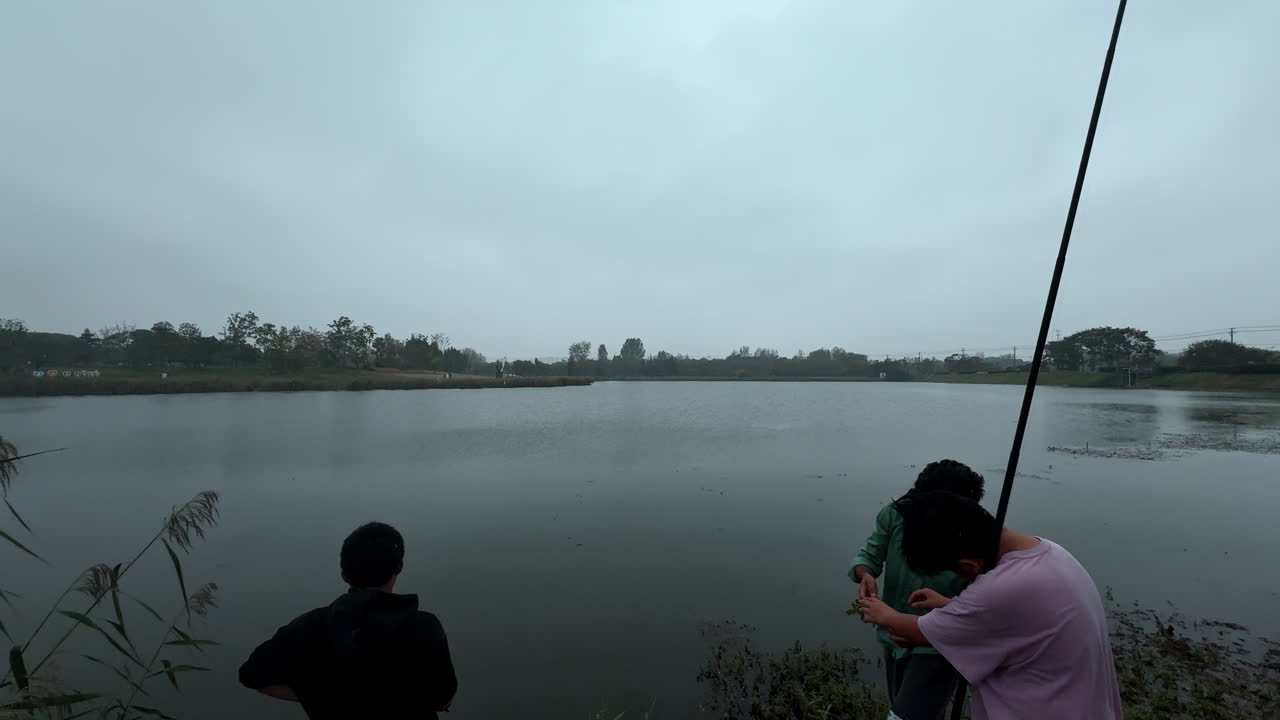 Men Fishing in a Calm Lake on a Cloudy Day