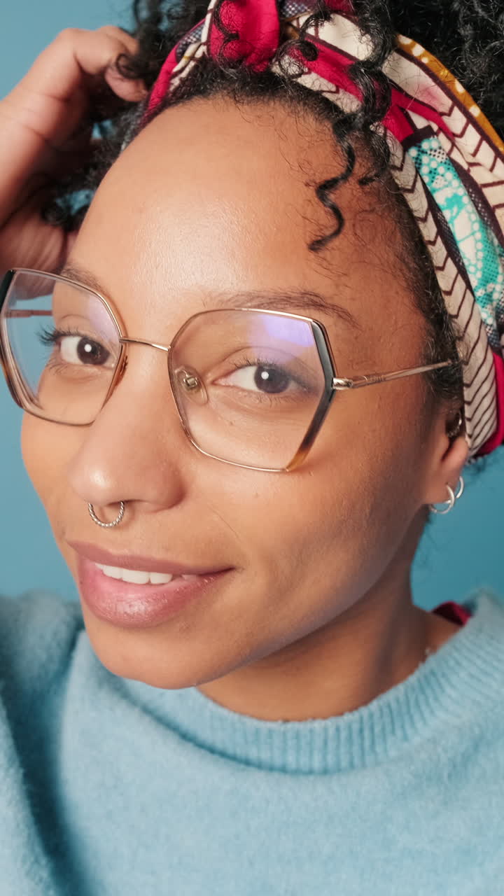 Smiling Young Woman with Glasses and Headband Posing in Studio