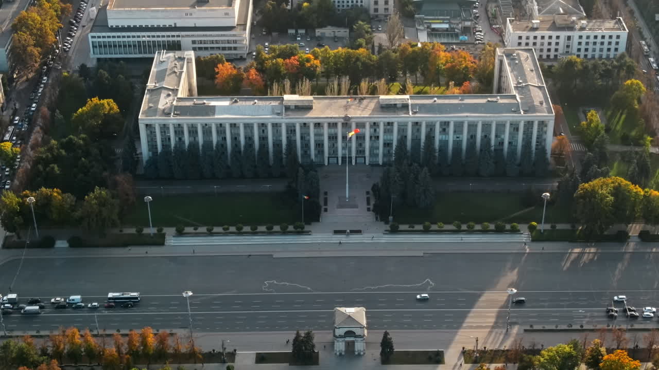 Aerial drone view of Chisinau downtown at sunset. Panorama view of Goverment building, Triumph Arch, roads with moving cars. Moldova