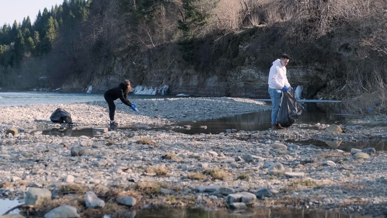 해변에서 플라스틱을 청소하는 팀워크: 자원봉사자들이 쓰레기 봉투에 쓰레기를 모으고, 플라스티크 오염과 환경 문제 개념: 플래스틱에서 자연을 자발적으로 청소하는 것, 지구를 녹색화하는 것