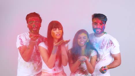 cuatro mejores amigos felices teniendo un gran tiempo tradicional de holi juntos en el estudio de fondo blanco