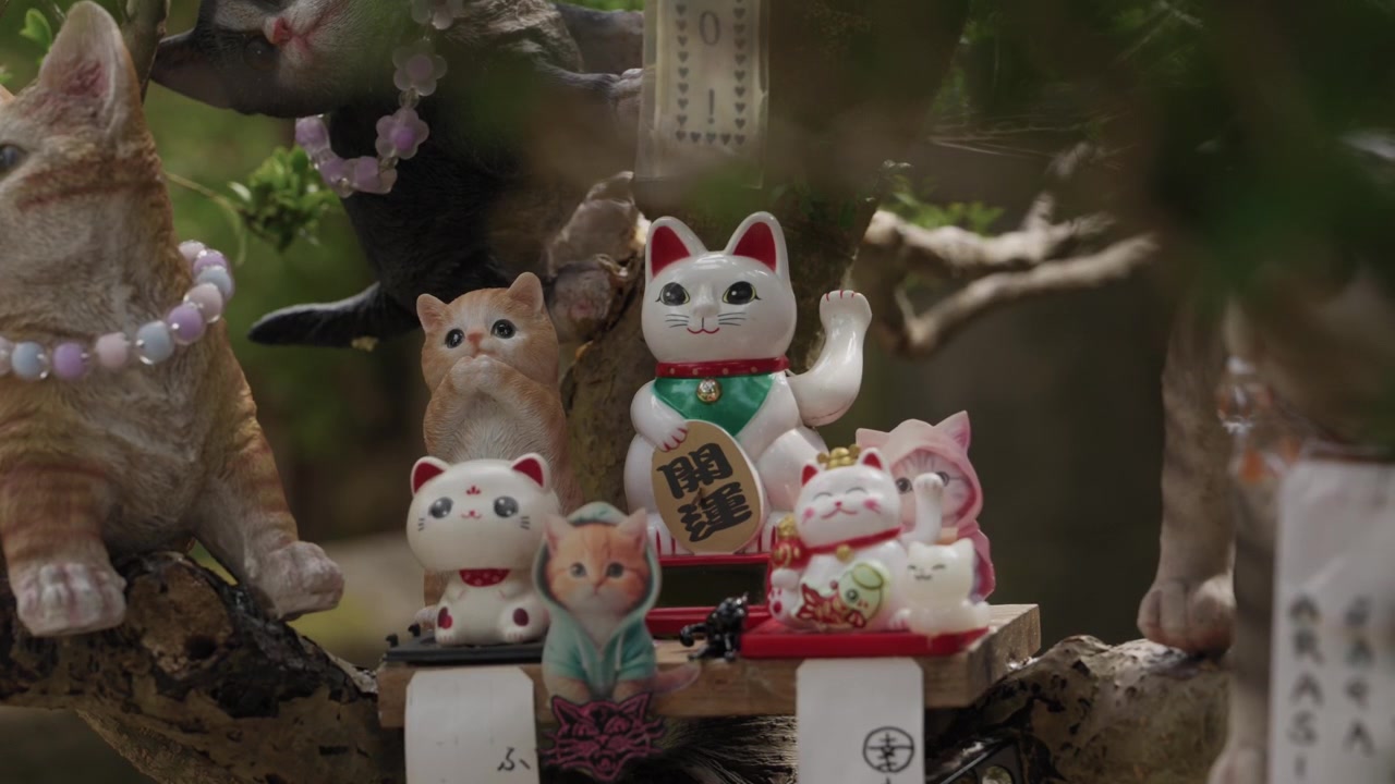 Kluster av maneki neko lyckokattfigurer och keramiska kattungar samlade vid en japansk helgedomsutställning i Japan.