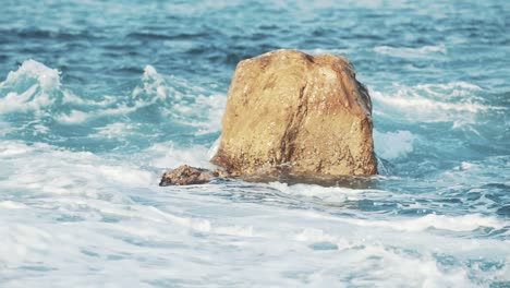 rock among a wavering waves near the island