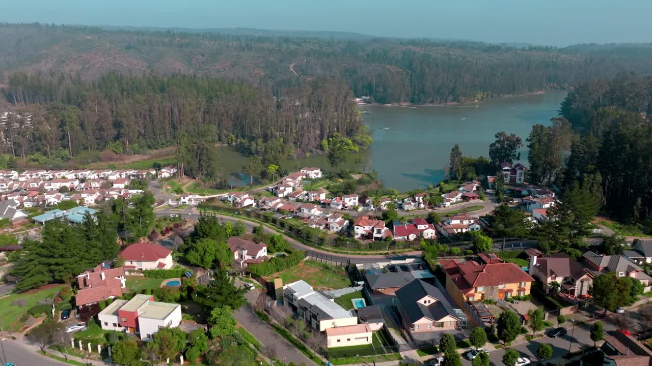drone sobrevuelo tranquilo vecino con la laguna de curauma como fondo, valparaiso suburbia, chile