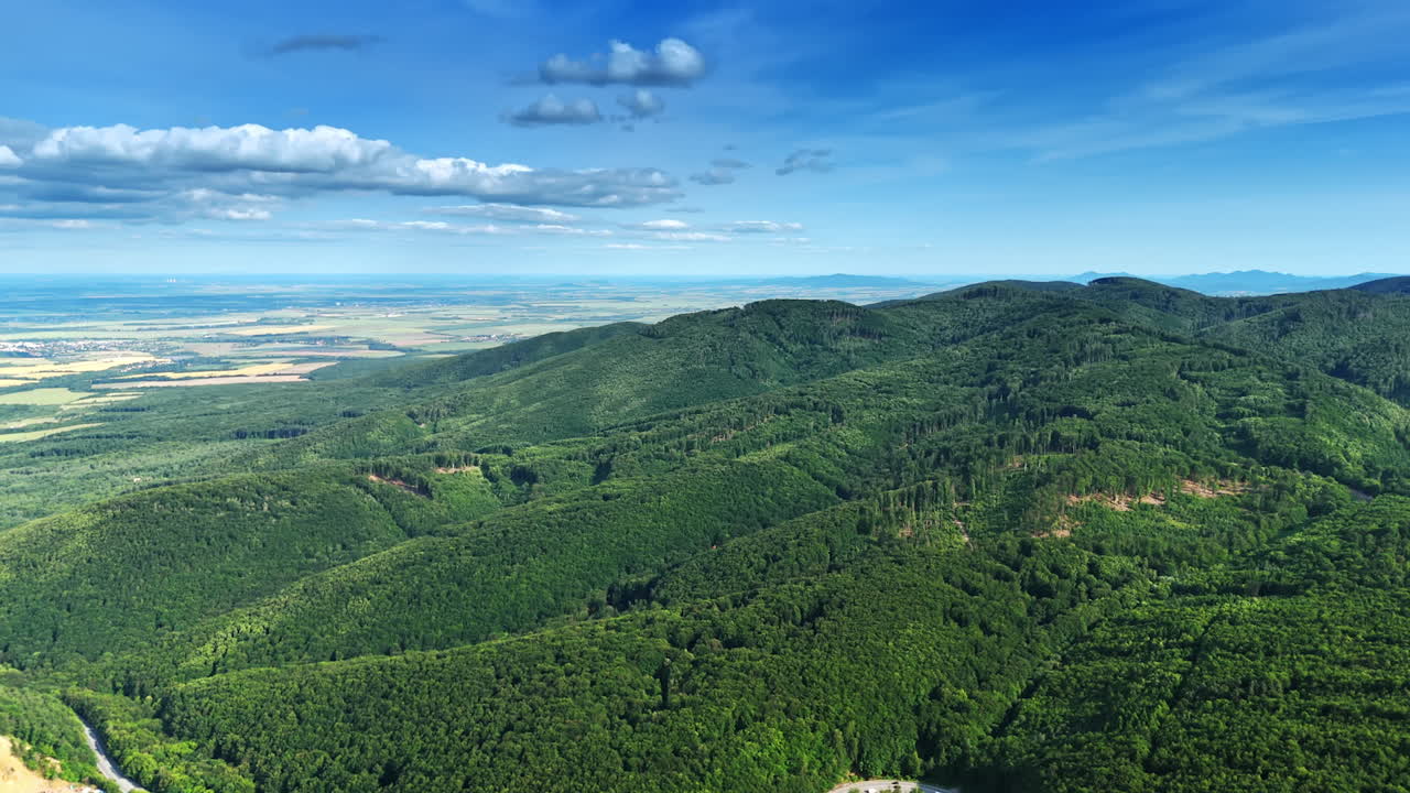 Green hills and skies in Europe. Rolling hills covered in vibrant greenery stretch under a bright sky with scattered clouds, showcasing natural beauty