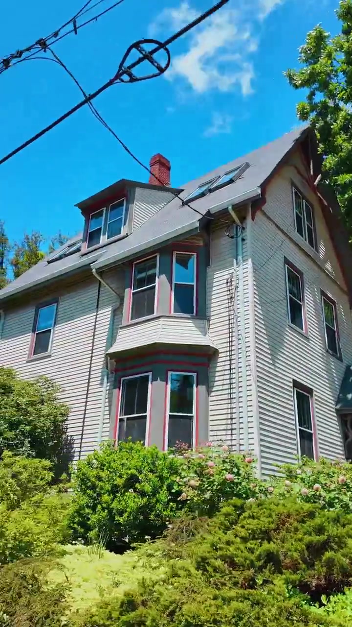 Boston, USA, 5 maggio 2025: Auto parcheggiate su una strada residenziale alberata in un quartiere di Boston. Vista diurna di una strada cittadina con veicoli parcheggiati, alti alberi verdi e case a schiera in mattoni.