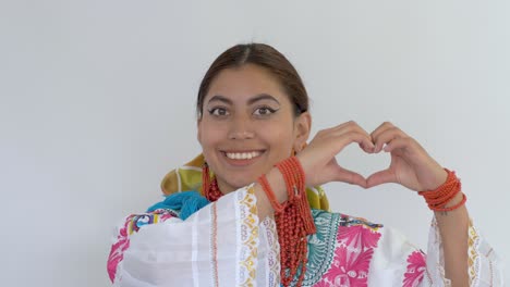 Filmclip-Einer-Jungen-Brünetten-Latina-In-Traditioneller-Cayambeñas-Tracht,-Die-Ein-Zeichen-Der-Liebe-Zeigt,-Indem-Sie-Mit-Ihren-Fingern-Ein-Herz-Formt