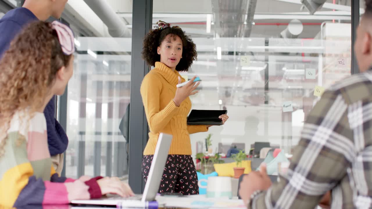 Happy diverse business people discussing work at meeting in office in slow motion