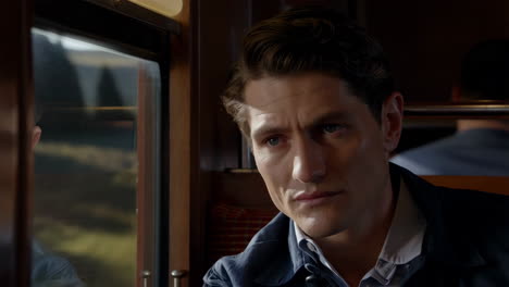 man looking out a train window