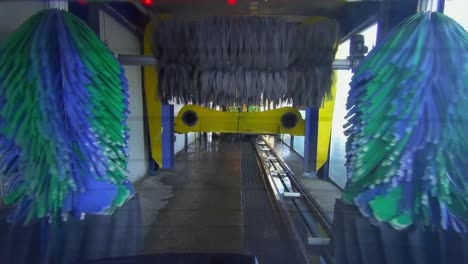 automatic car wash as seen from back of vehicle moving through machine rollers