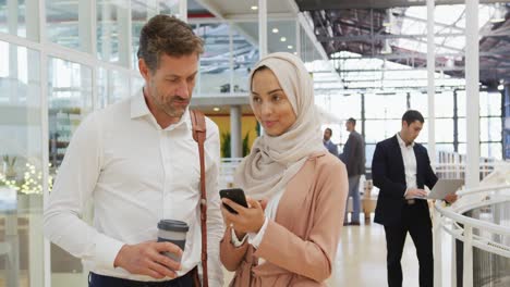 business people using a smartphone in a conference foyer