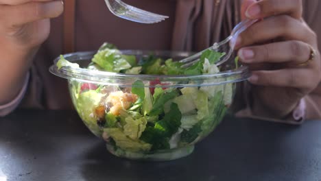 woman eating a salad outdoors