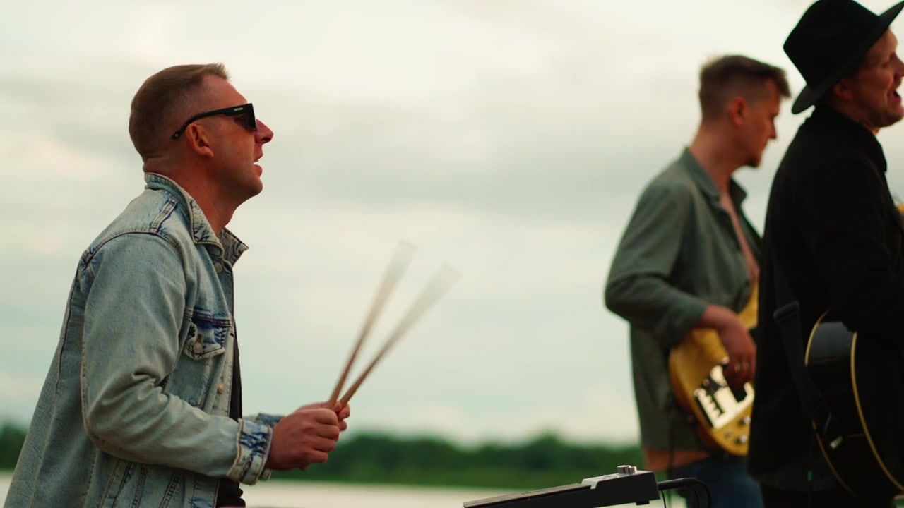 Musiker spielt elektronisches Schlagzeug im Freien mit Band