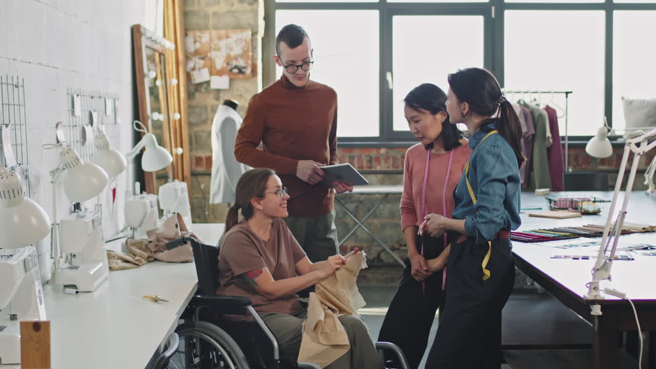 Seamstress in Wheelchair Showing Garment to Fashion Designers