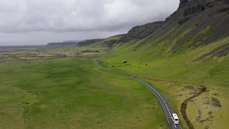 Tourbus-Fährt-Durch-Die-Berge-Islands-Mit-Drohnenvideoverfolgung