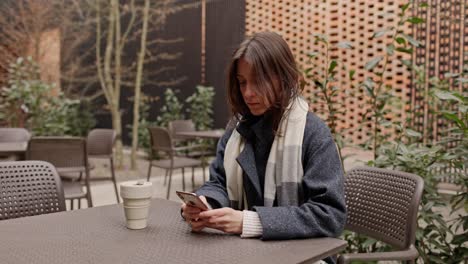 woman using phone in a cafe