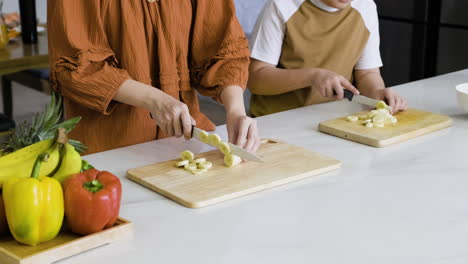 mom and boy cutting bananas.