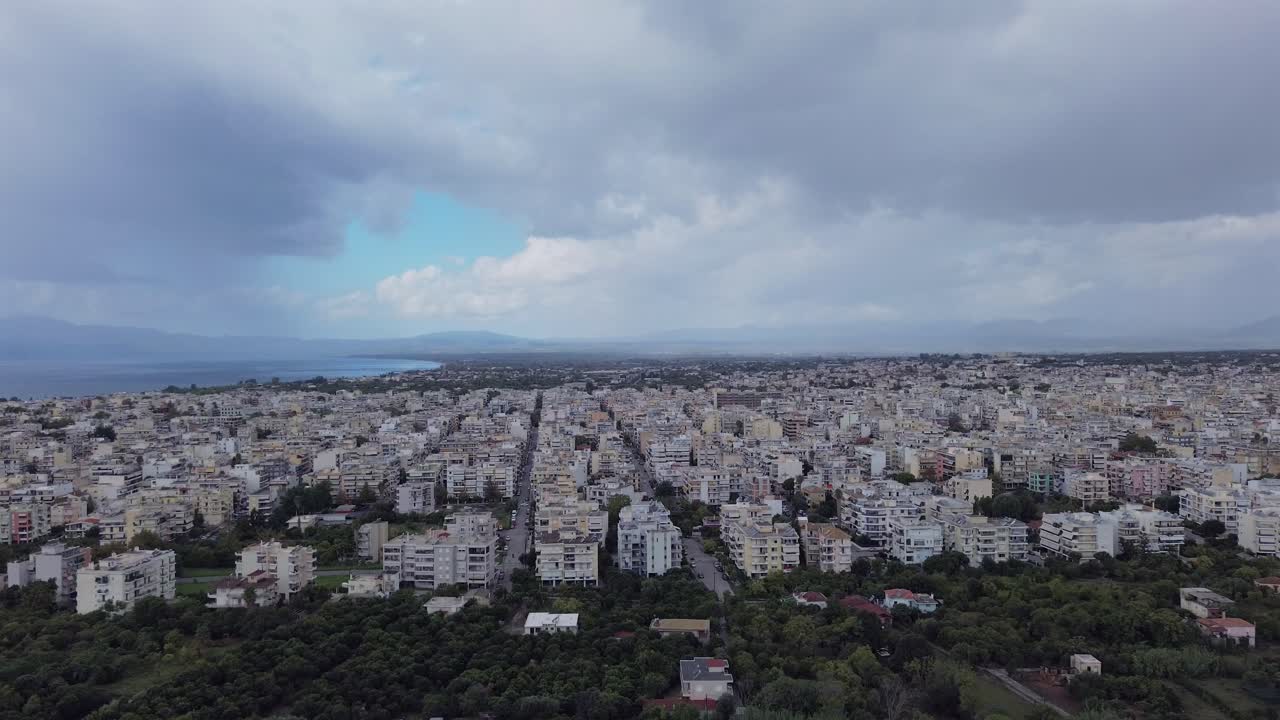 Aerial establishing cityscape of Kalamata city on a cloudy autumn day, push out, raise up revealing footage 4K