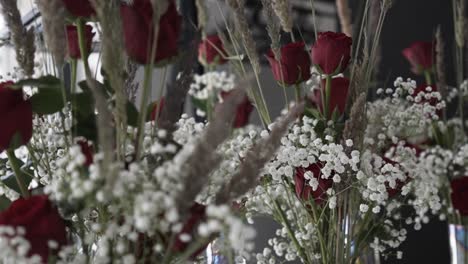 Primer-Plano-De-La-Mano-Ajustar-Rosa-Roja,-Trigo,-Decoración-De-Boda-De-Flores-De-Yeso