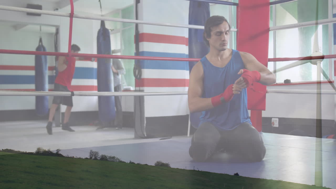 In boxing gym, man wrapping hands with animation of grassy field landscape