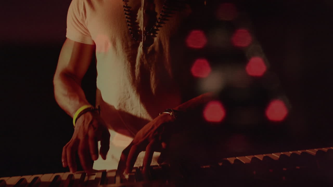 Animation of blurred night road traffic over caucasian man playing keyboard on concert