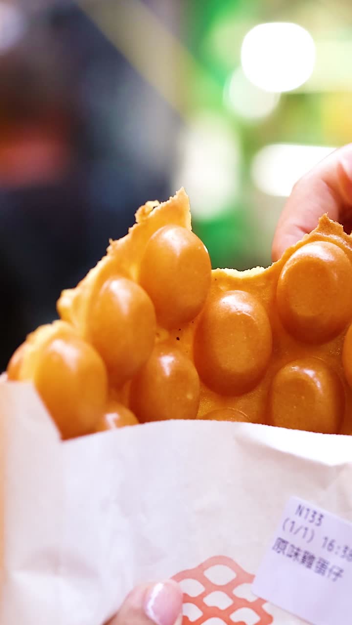 손을 잡고 야외에서 버블 와플을 먹는 것