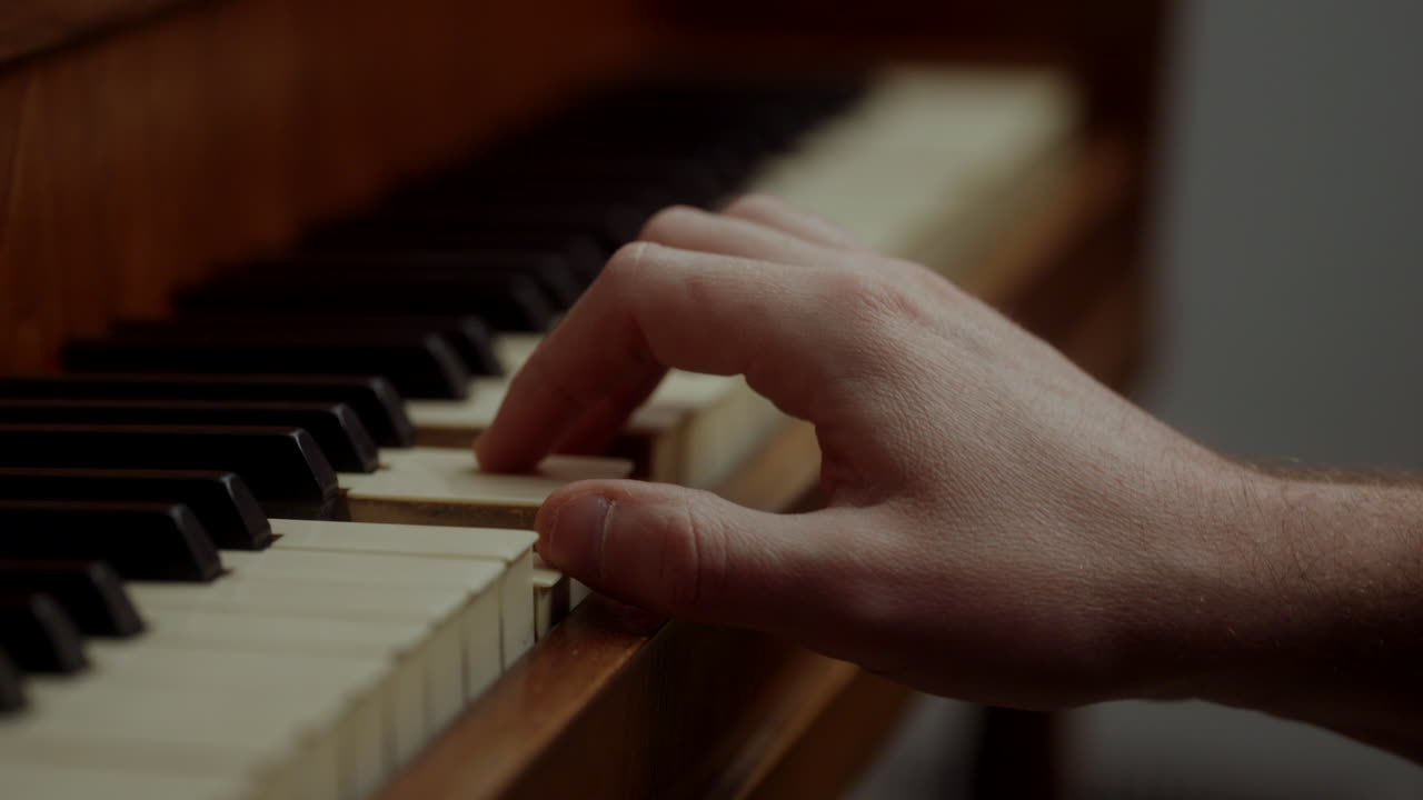 Close-up of a Man's Hand Playing an Old Piano