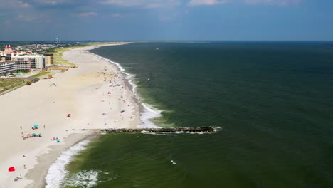 Dolly-Aéreo-De-Drones-Disparado-Hacia-Adelante-Sobre-La-Playa-En-Oceanside,-Nueva-York,-Luego-Se-Eleva-Para-Ver-El-Horizonte